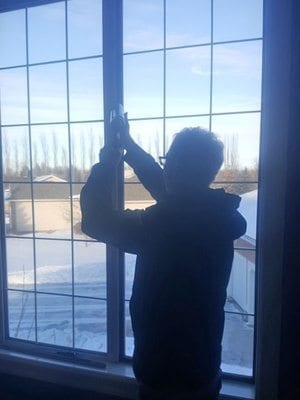 Man repairs window hinge